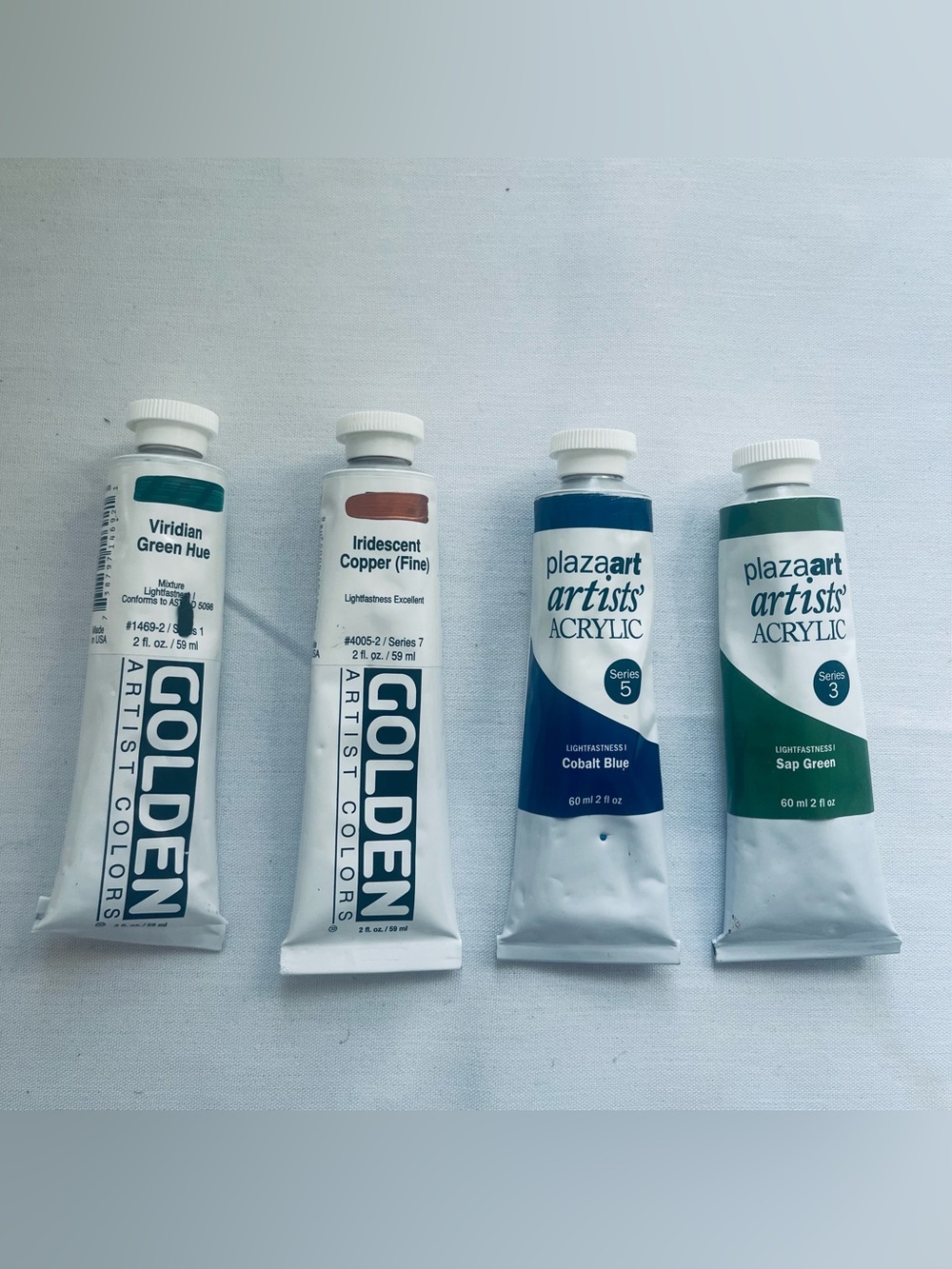 four tubes of professional and student-grade artist acrylic paint
